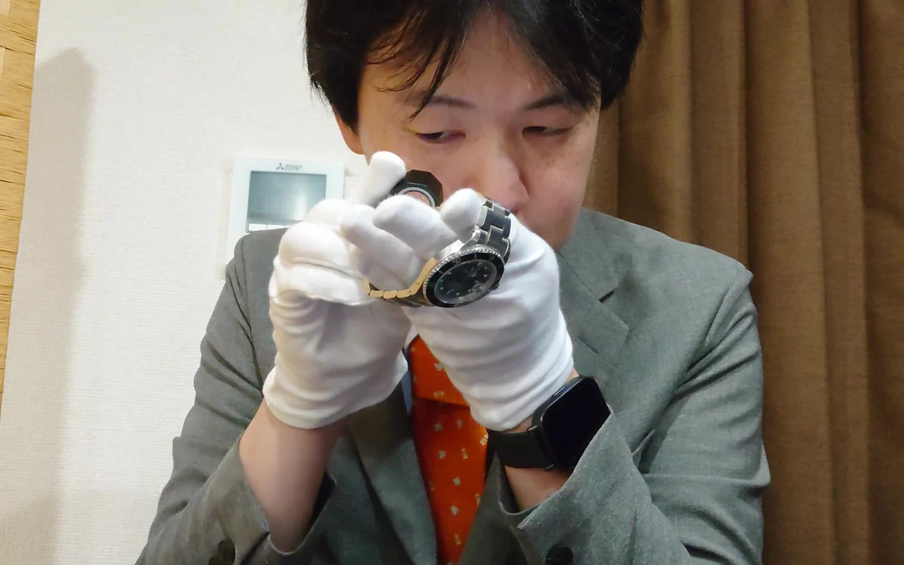 ルーペで時計を確認している査定の場面