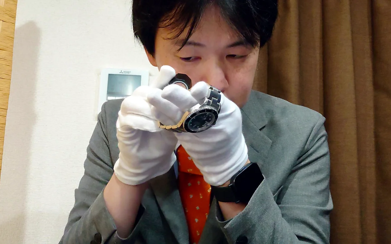 ルーペで時計を確認している査定の場面